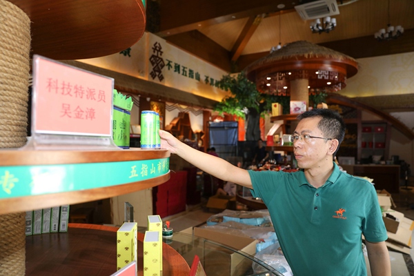 五指山市科技特派员吴金漳在展示当地特色电商产品。(李天平摄)