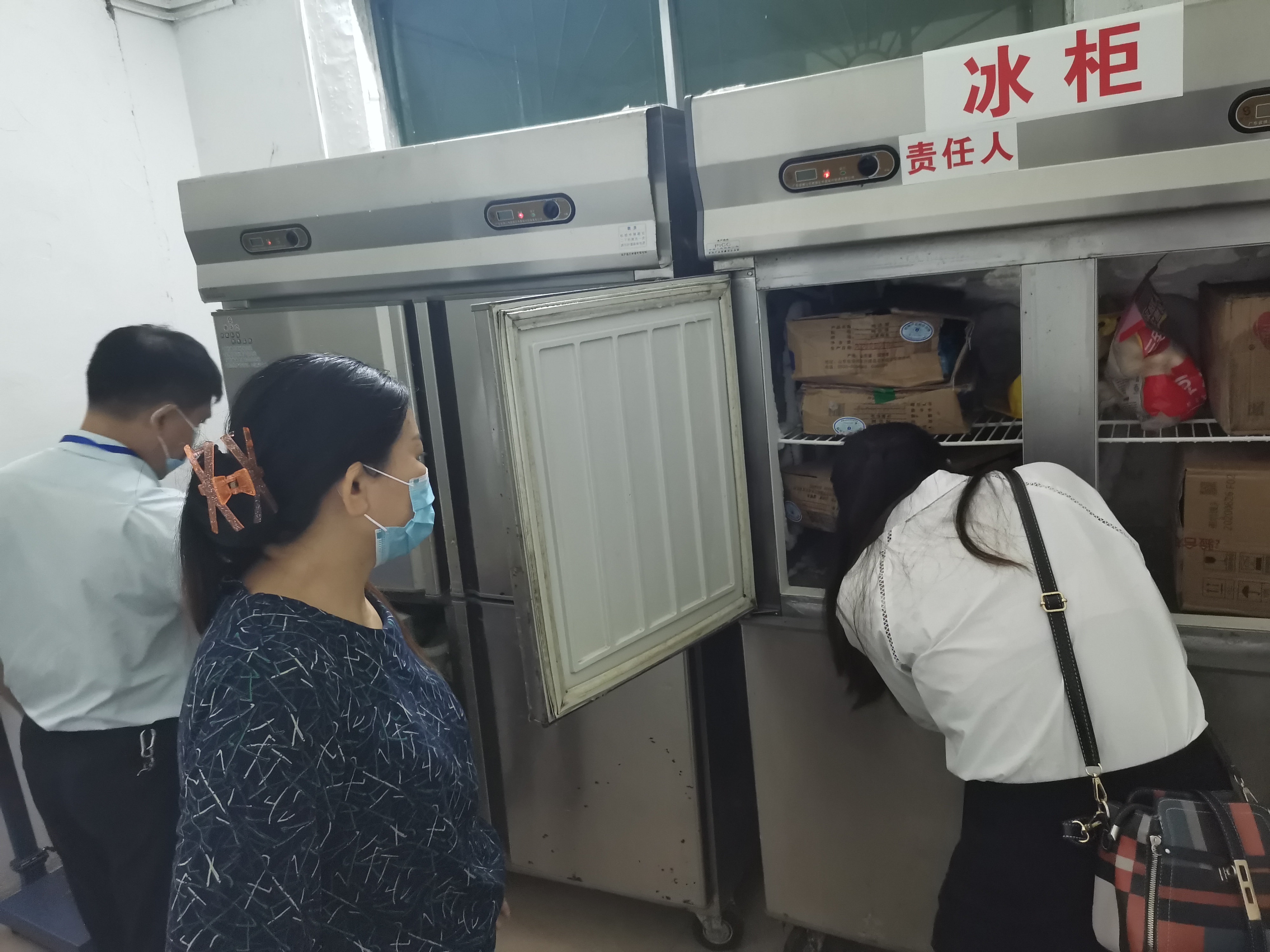 执法人员查看学校冻库情况.jpg