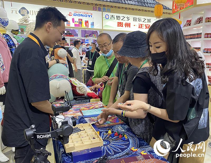 观众正在选购贵州馆展示的苗族银饰。人民网记者 杜燕飞摄